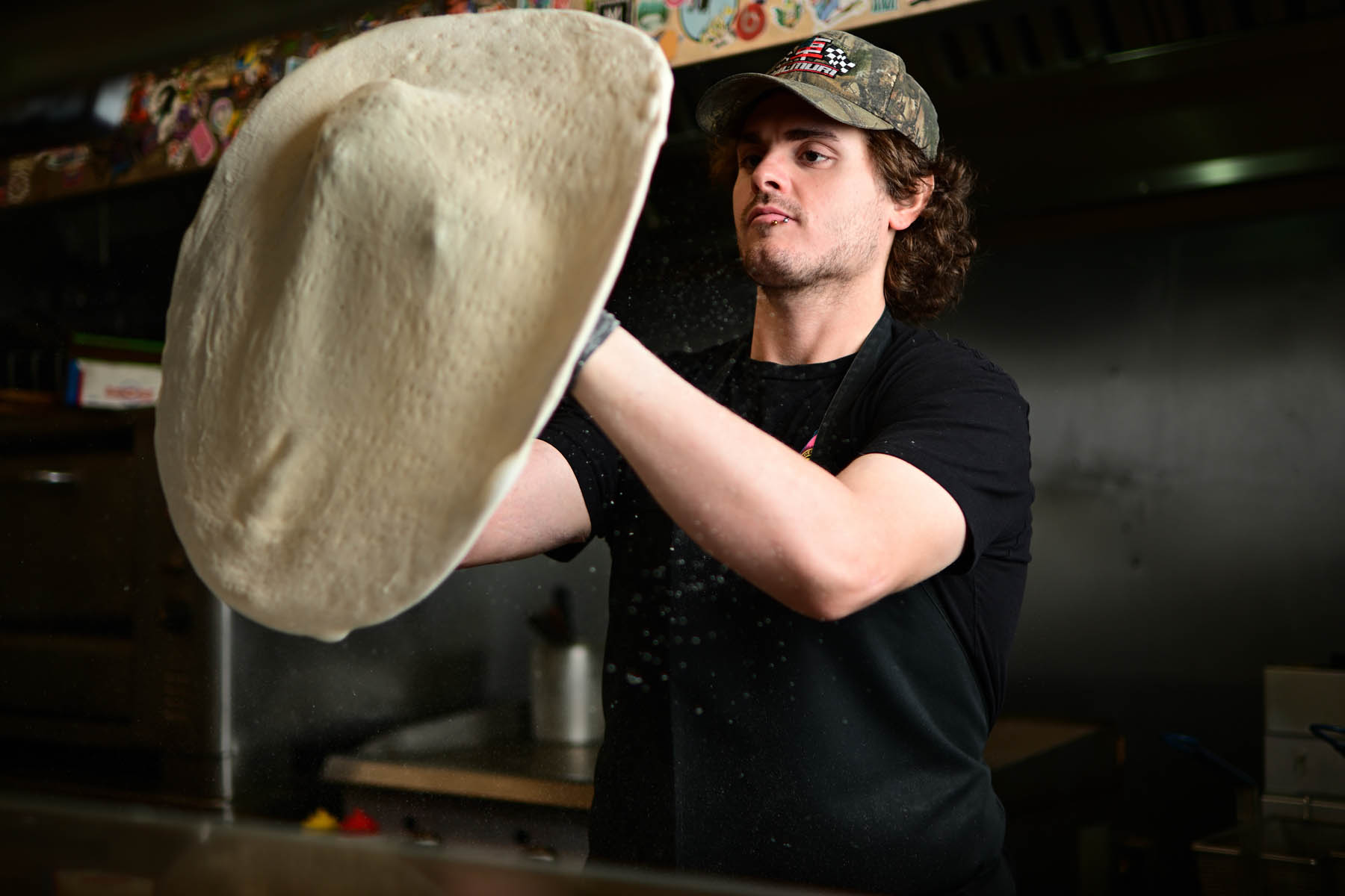 Fresh pizza dough being tossed